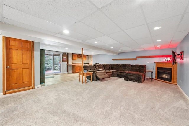 living room with a paneled ceiling and carpet floors