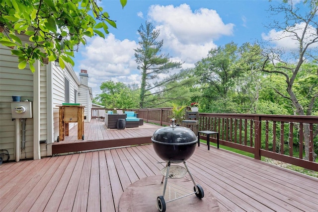 wooden terrace featuring an outdoor living space with a fire pit