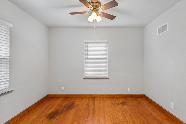 unfurnished room with plenty of natural light, ceiling fan, and wood-type flooring