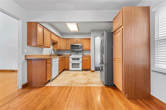 kitchen featuring light wood-type flooring, stainless steel appliances, and sink