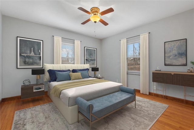 bedroom featuring multiple windows, ceiling fan, and hardwood / wood-style flooring