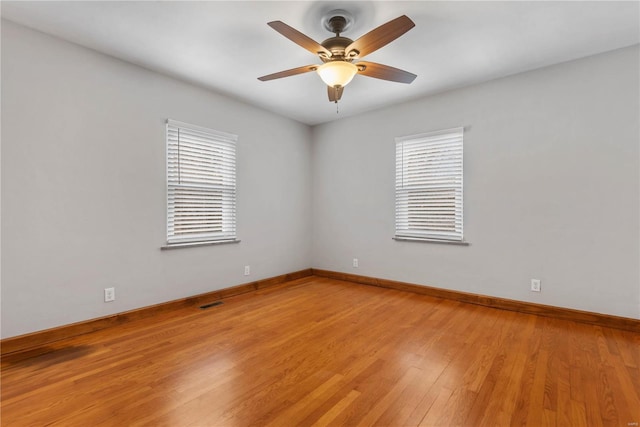 empty room featuring ceiling fan, plenty of natural light, and light hardwood / wood-style floors