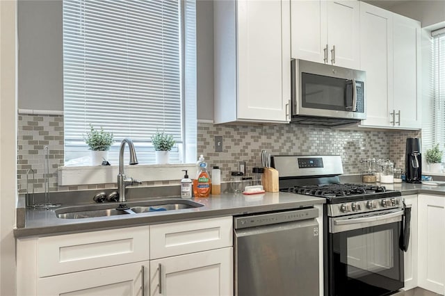 kitchen with white cabinets, decorative backsplash, sink, and appliances with stainless steel finishes