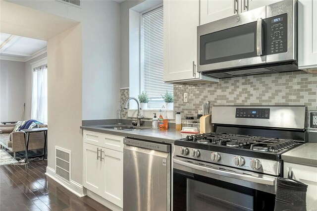 kitchen with stainless steel appliances, white cabinetry, and sink