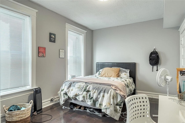 bedroom with dark wood-type flooring and a textured ceiling