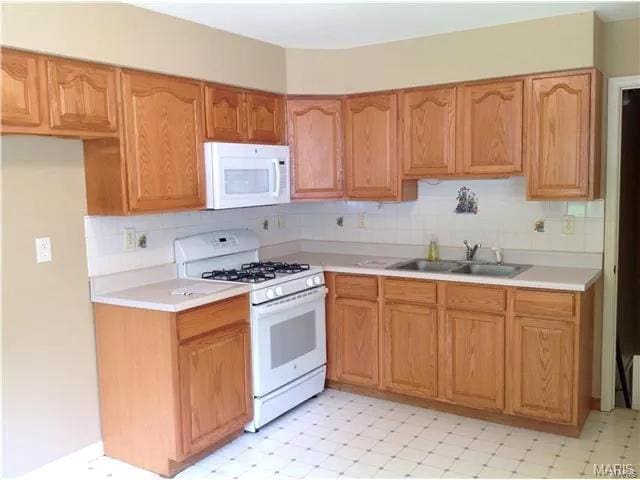 kitchen featuring white appliances and sink