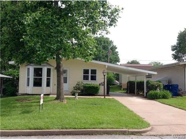 ranch-style home featuring a front yard and a carport