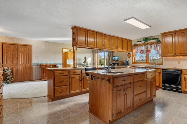 kitchen featuring kitchen peninsula, a textured ceiling, sink, dishwasher, and an island with sink