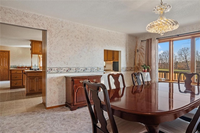 carpeted dining room with sink and an inviting chandelier