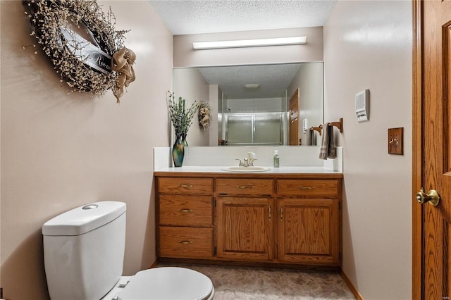 bathroom with vanity, an enclosed shower, a textured ceiling, and toilet