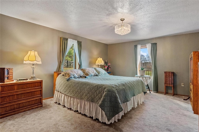 bedroom featuring light colored carpet, a textured ceiling, and an inviting chandelier