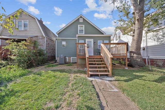 back of house with central AC unit, a lawn, and a deck