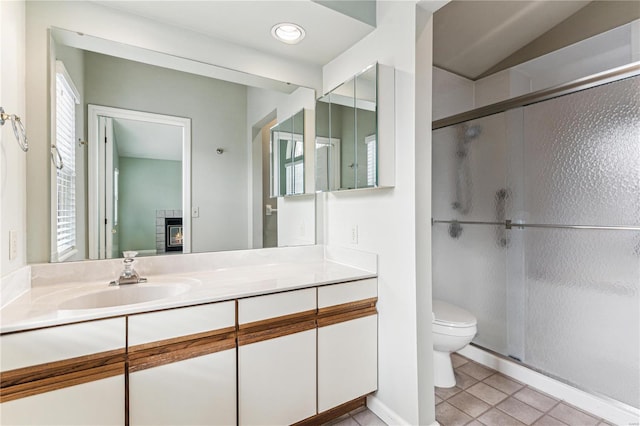 bathroom featuring tile patterned floors, toilet, vanity, and walk in shower