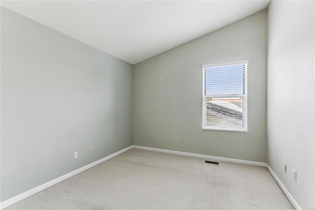 carpeted spare room featuring lofted ceiling