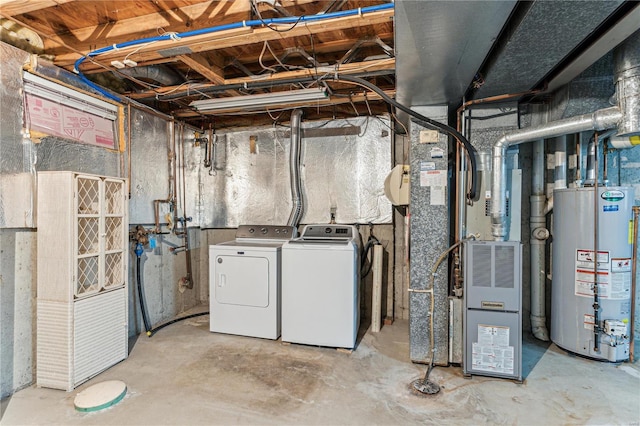 basement featuring heating unit, washing machine and clothes dryer, and water heater