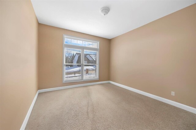 unfurnished room with carpet flooring and baseboards