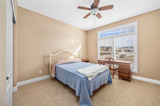 bedroom with light carpet, ceiling fan, and baseboards