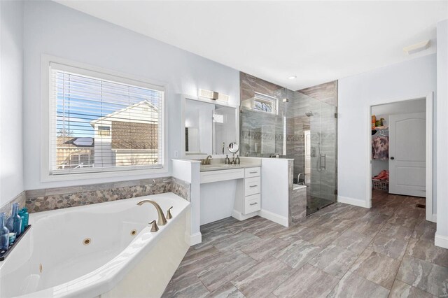 full bath with a stall shower, vanity, baseboards, and a whirlpool tub