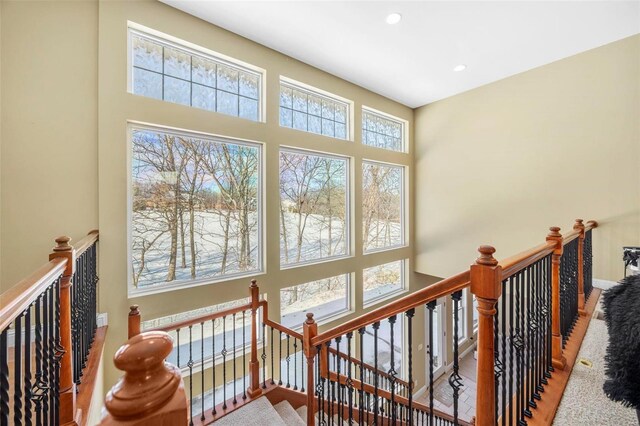 staircase with recessed lighting, baseboards, and a towering ceiling