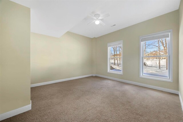 carpeted empty room with visible vents, baseboards, and ceiling fan