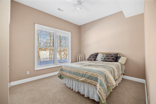 carpeted bedroom with visible vents, baseboards, and ceiling fan