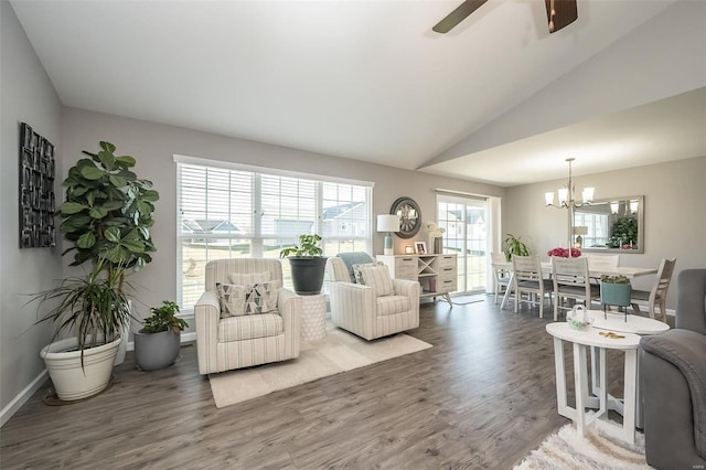 living room with vaulted ceiling, ceiling fan with notable chandelier, and hardwood / wood-style floors