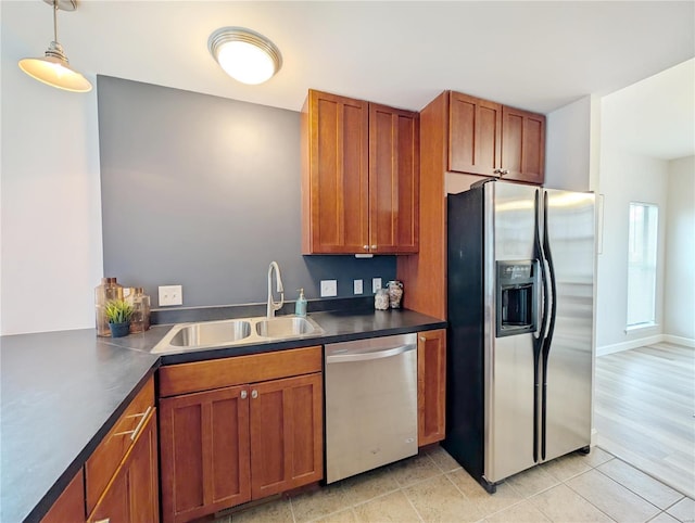 kitchen featuring decorative light fixtures, sink, light tile patterned floors, and stainless steel appliances