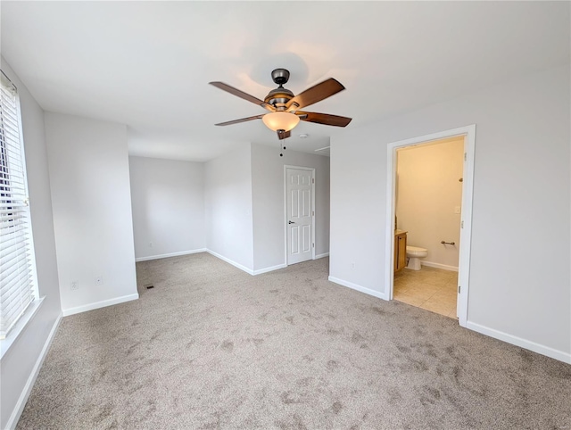 spare room featuring light carpet and ceiling fan