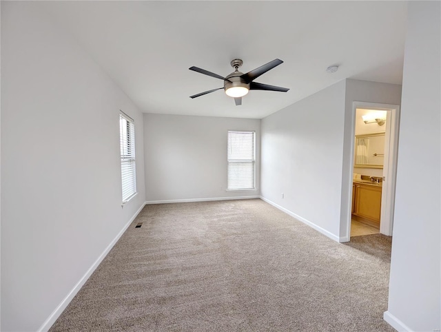 carpeted spare room with ceiling fan