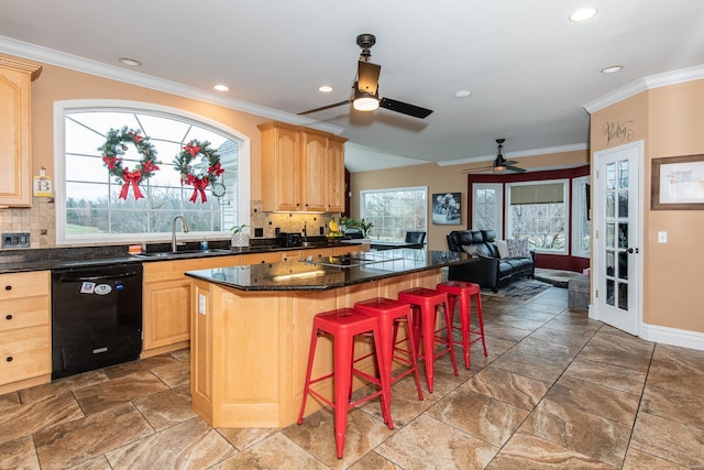 kitchen with a kitchen bar, light brown cabinetry, sink, dishwasher, and a center island