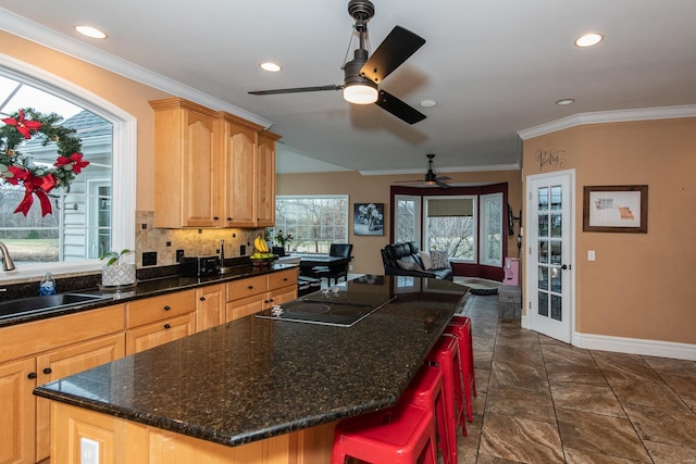 kitchen featuring a wealth of natural light, sink, a center island, and black electric stovetop