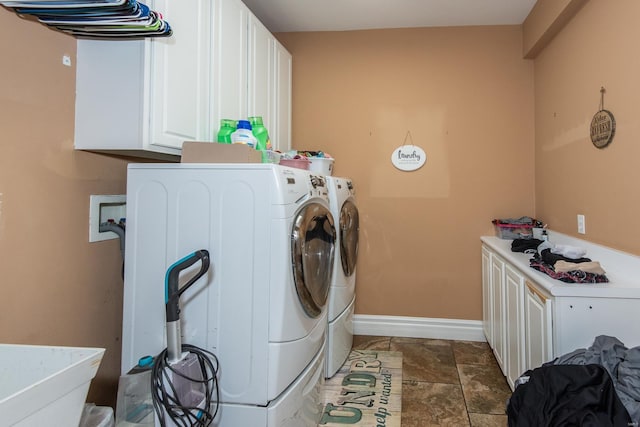 clothes washing area with cabinets and washer and dryer