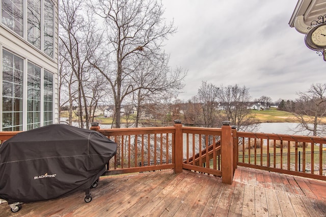 wooden deck featuring area for grilling and a water view