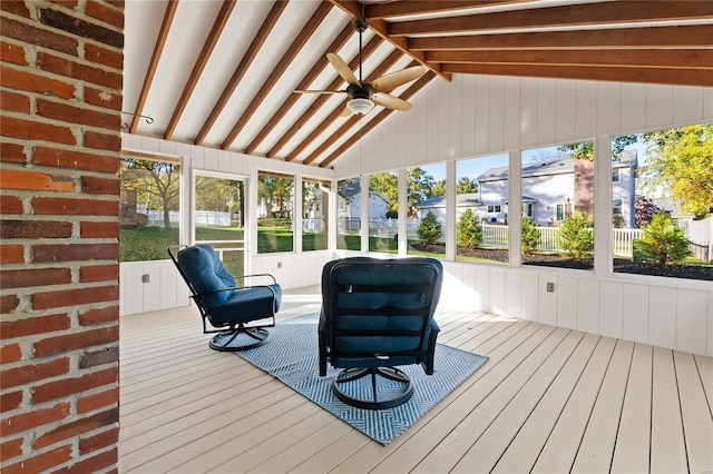 unfurnished sunroom with ceiling fan and vaulted ceiling