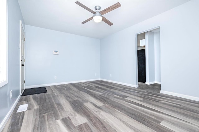 empty room featuring ceiling fan and dark wood-type flooring