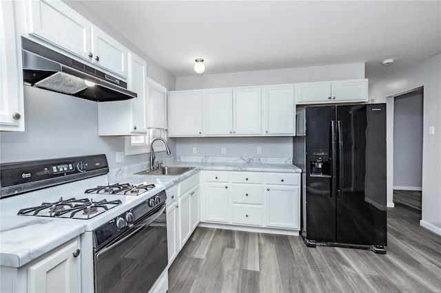 kitchen with sink, white cabinets, black fridge with ice dispenser, and white gas stove