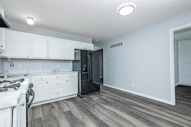 kitchen featuring gas range oven, dark hardwood / wood-style floors, black refrigerator with ice dispenser, white cabinets, and sink