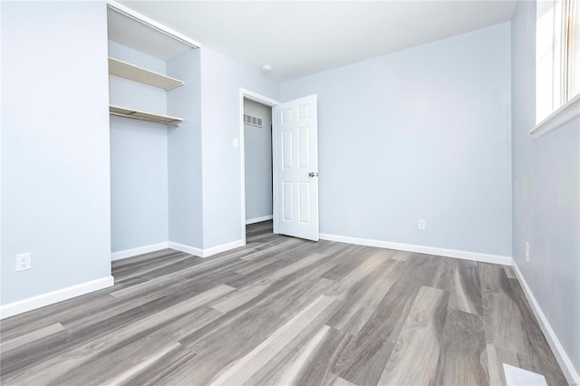 unfurnished bedroom with hardwood / wood-style floors and a closet