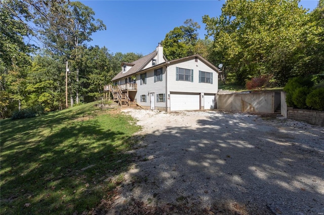 view of side of home with a lawn, a garage, and a wooden deck