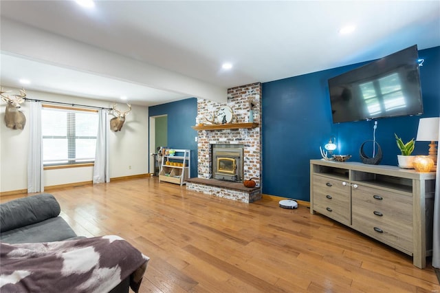 living room with a wood stove and light wood-type flooring