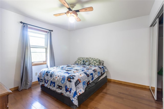 bedroom featuring ceiling fan, dark wood-type flooring, and a closet