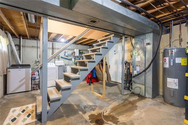 basement featuring heating unit, independent washer and dryer, electric water heater, and fridge