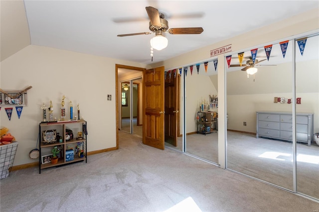 carpeted bedroom with two closets, ceiling fan, and lofted ceiling