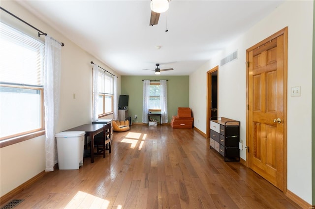 interior space with ceiling fan and wood-type flooring