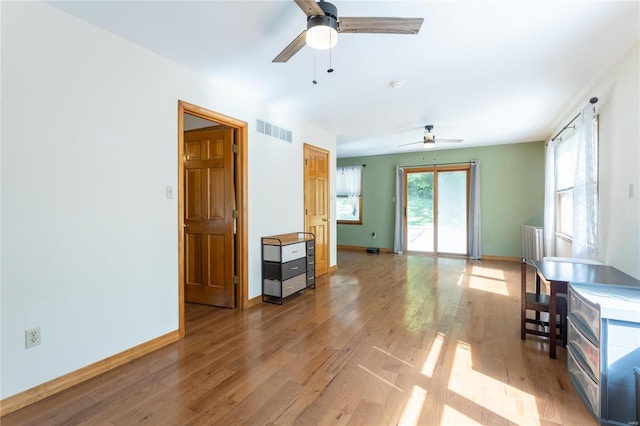 living room with ceiling fan and light wood-type flooring