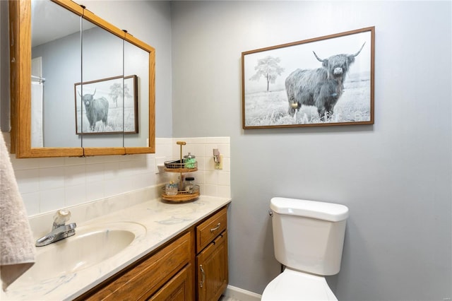 bathroom featuring decorative backsplash, toilet, and vanity