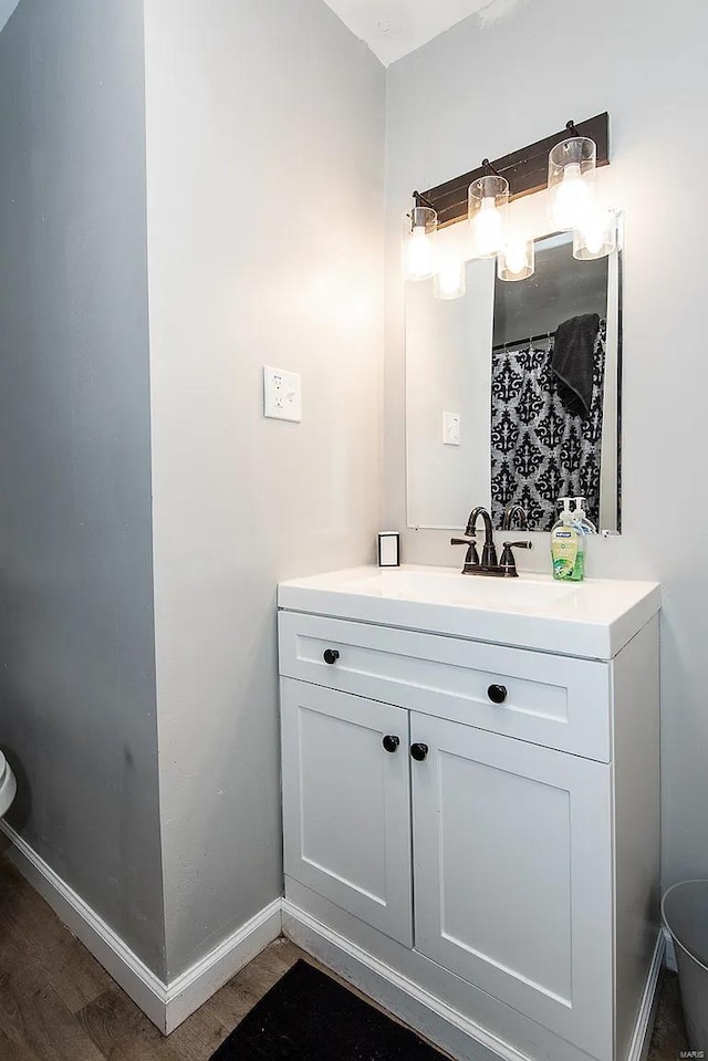 bathroom with vanity, hardwood / wood-style flooring, and toilet