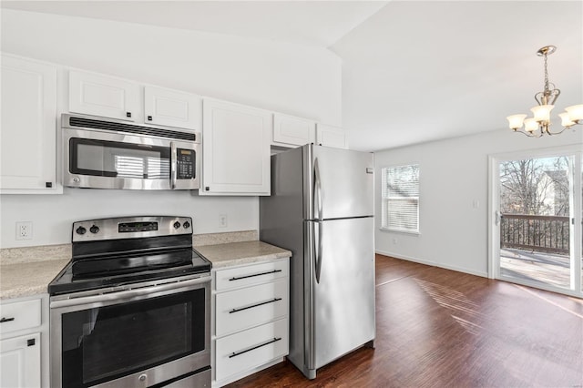 kitchen with an inviting chandelier, white cabinets, vaulted ceiling, dark hardwood / wood-style flooring, and stainless steel appliances