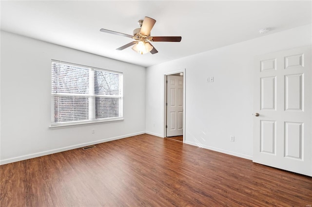 spare room with ceiling fan and dark wood-type flooring