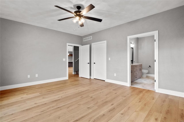 unfurnished bedroom with connected bathroom, light hardwood / wood-style floors, and ceiling fan